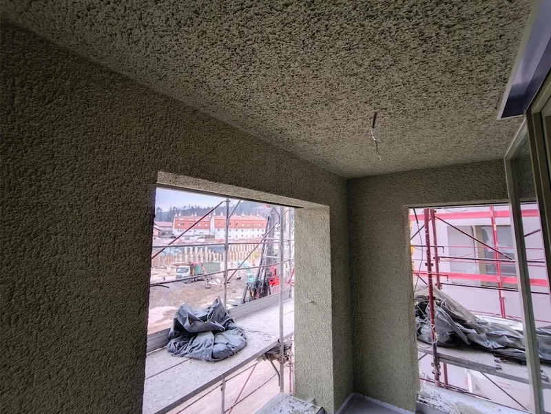 Dve odprtini lože z zelenim strukturiranim ometom in vidnim gradbenim odrom.