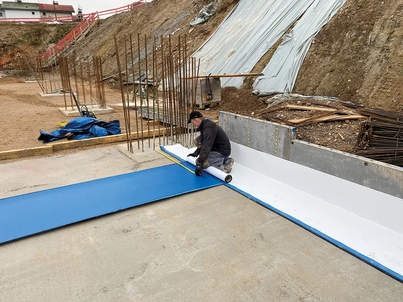 Polaganje hidroizolacijske membrane Mapeproof AL-AP ob robu armiranobetonske temeljne plošče.