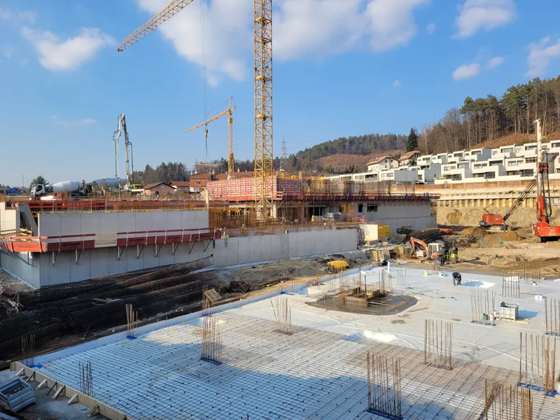Gradnja armiranobetonske konstrukcije in plošč v gradbeni jami.